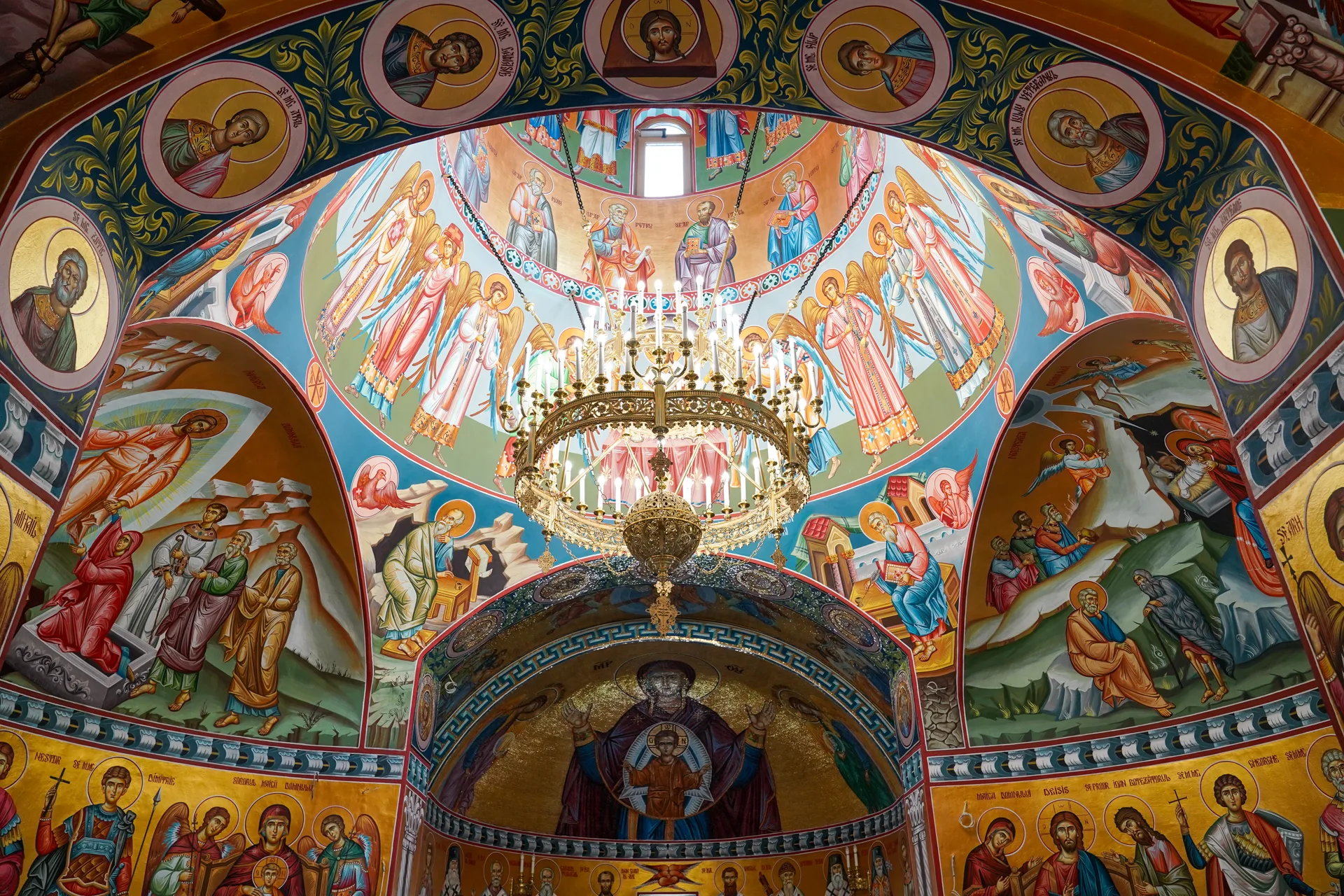 Interiorul bisericii cu fresce bizantine și candelabru