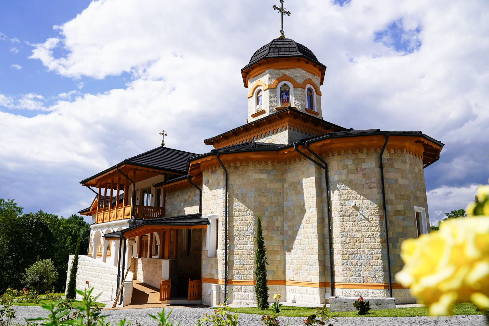 Biserica din piatră naturală cu turlă și cruce